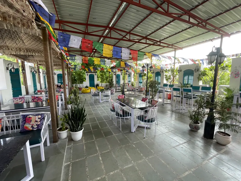 Covered rooftop event venue with prayer flags and seating at J Brew N Kitchen, Jaipur