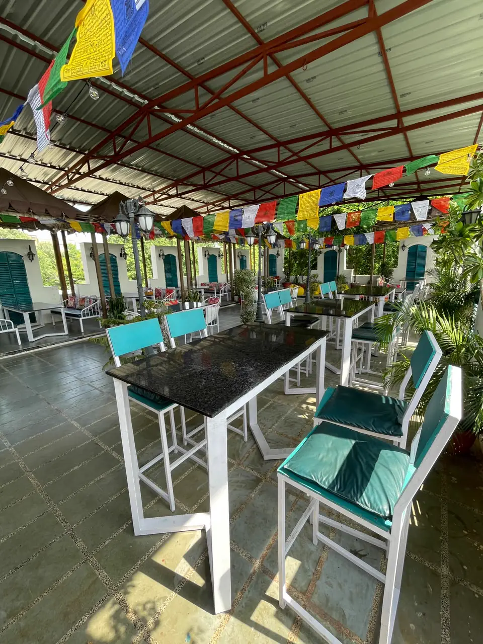 Granite tables with teal chairs on the rooftop